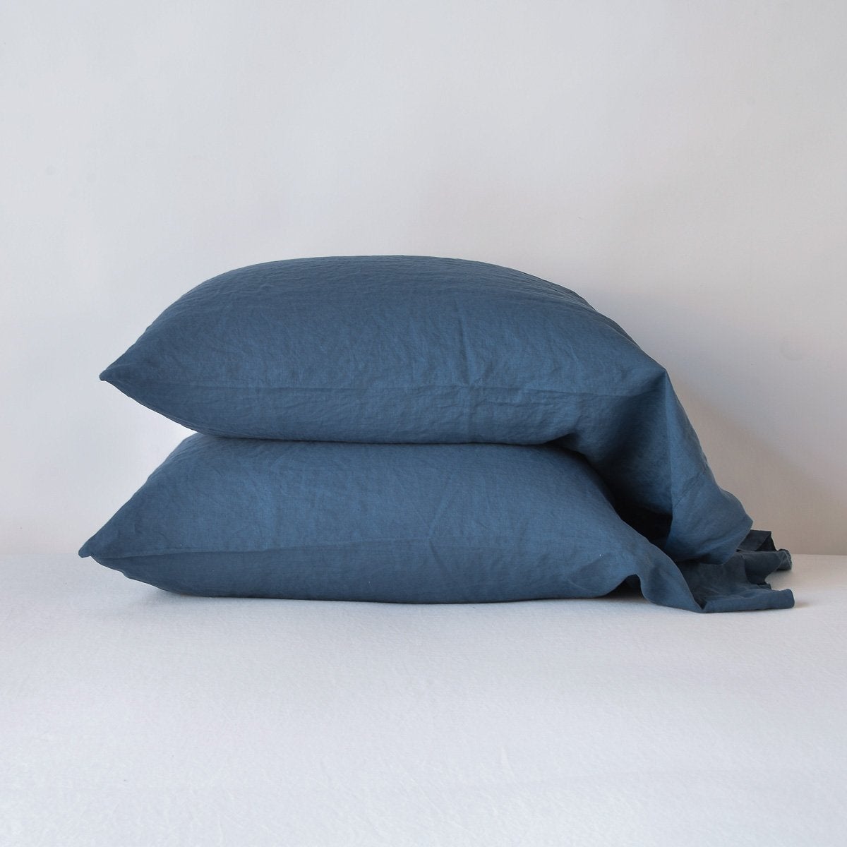 Two Bella Notte Linen pillowcases stacked, Midnight, relaxed linen texture.