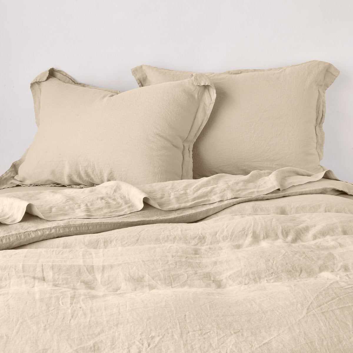 Honeycomb linen sham styled on a made bed with matching duvet, relaxed drape visible.