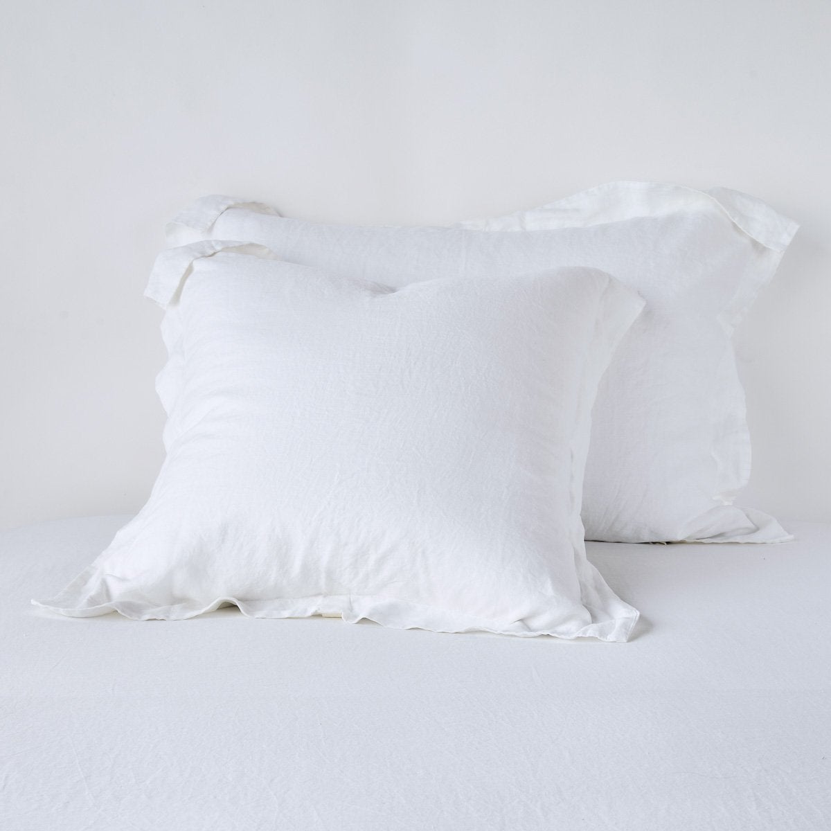 Bella Notte Linen sham in White, two Euro shams with ruffled edges on white bedding.