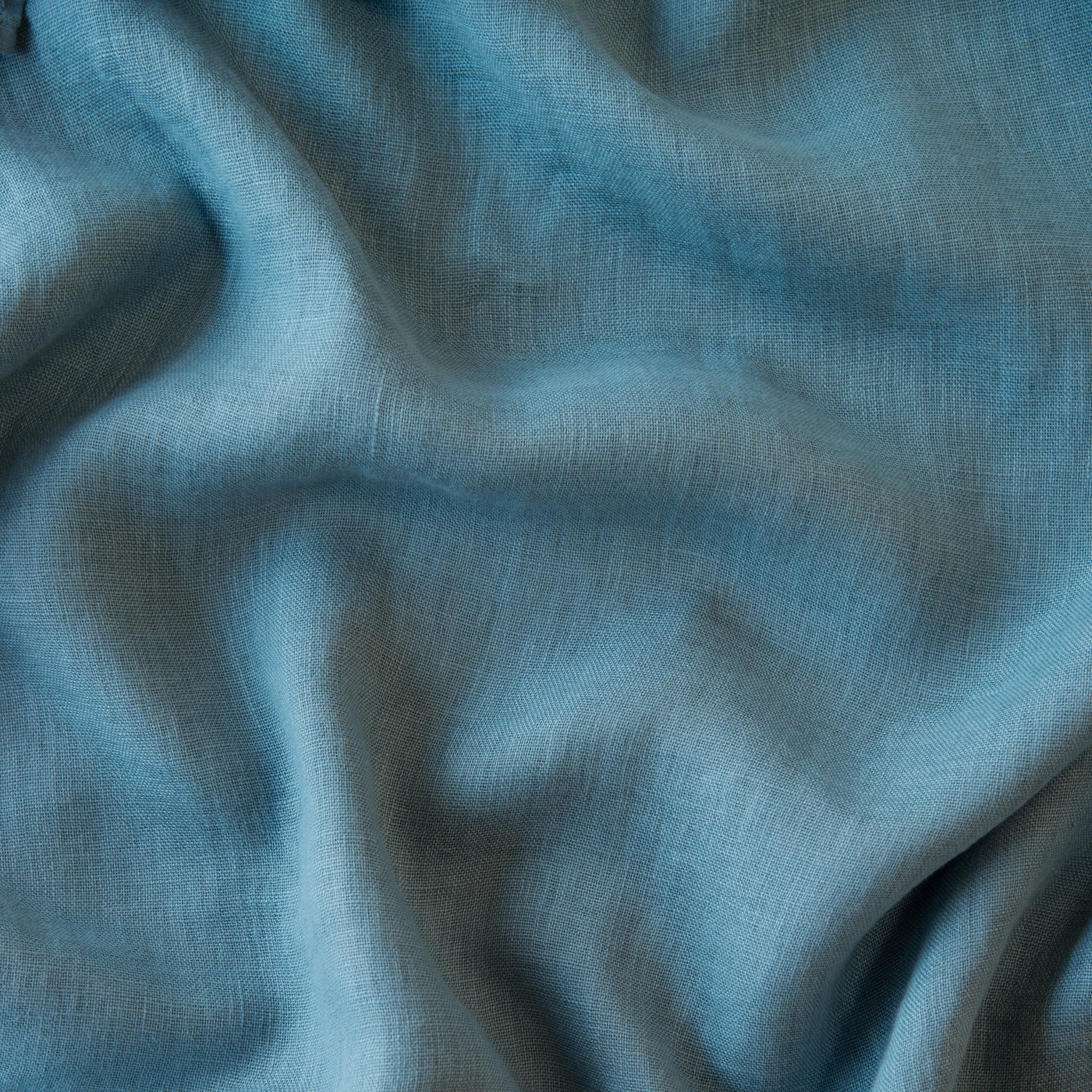 Close-up of Cenote Linen Whisper fabric showing draped washed linen texture and natural slub weave.