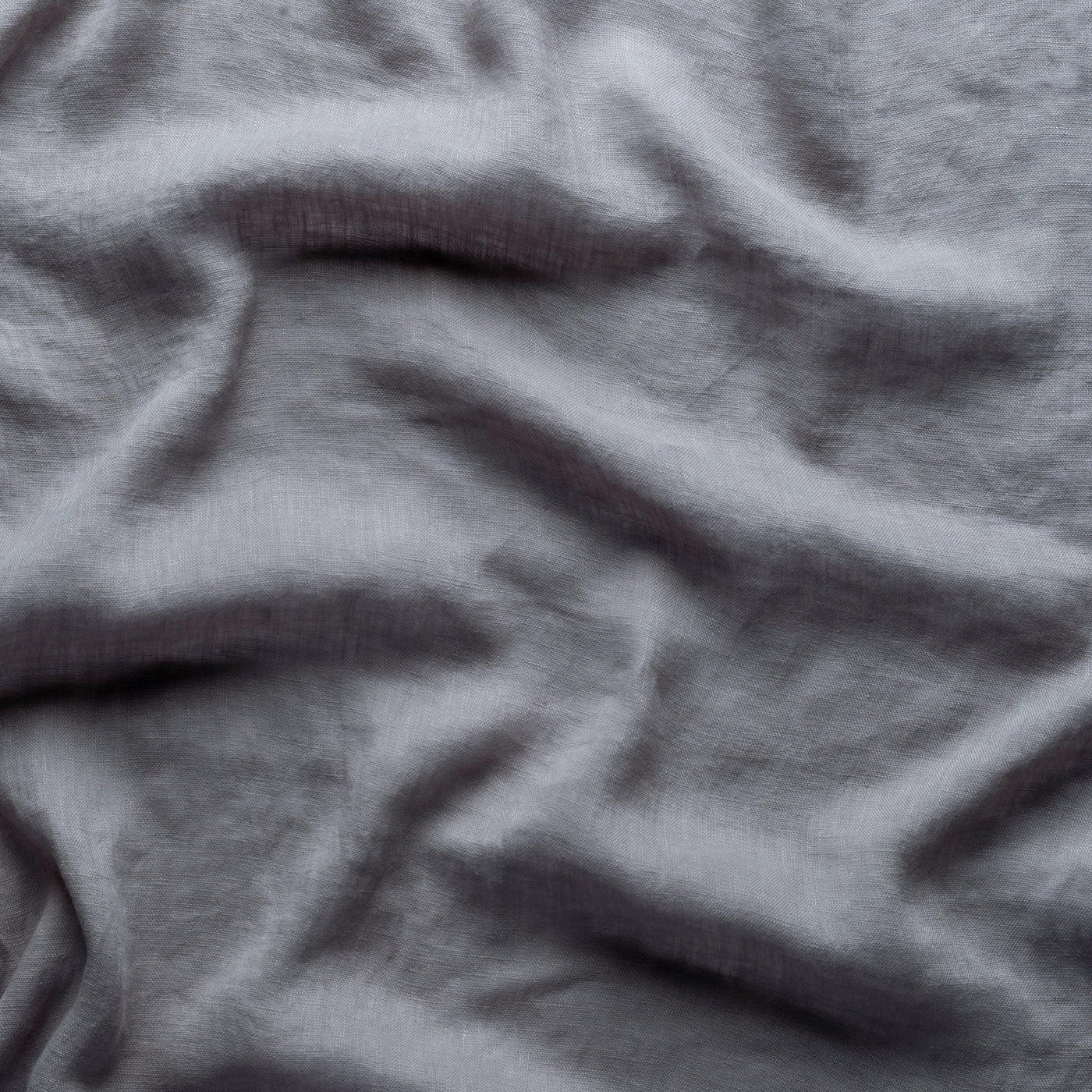 Close-up of draped Bella Notte Linen Whisper fabric showing soft grey texture and folds.