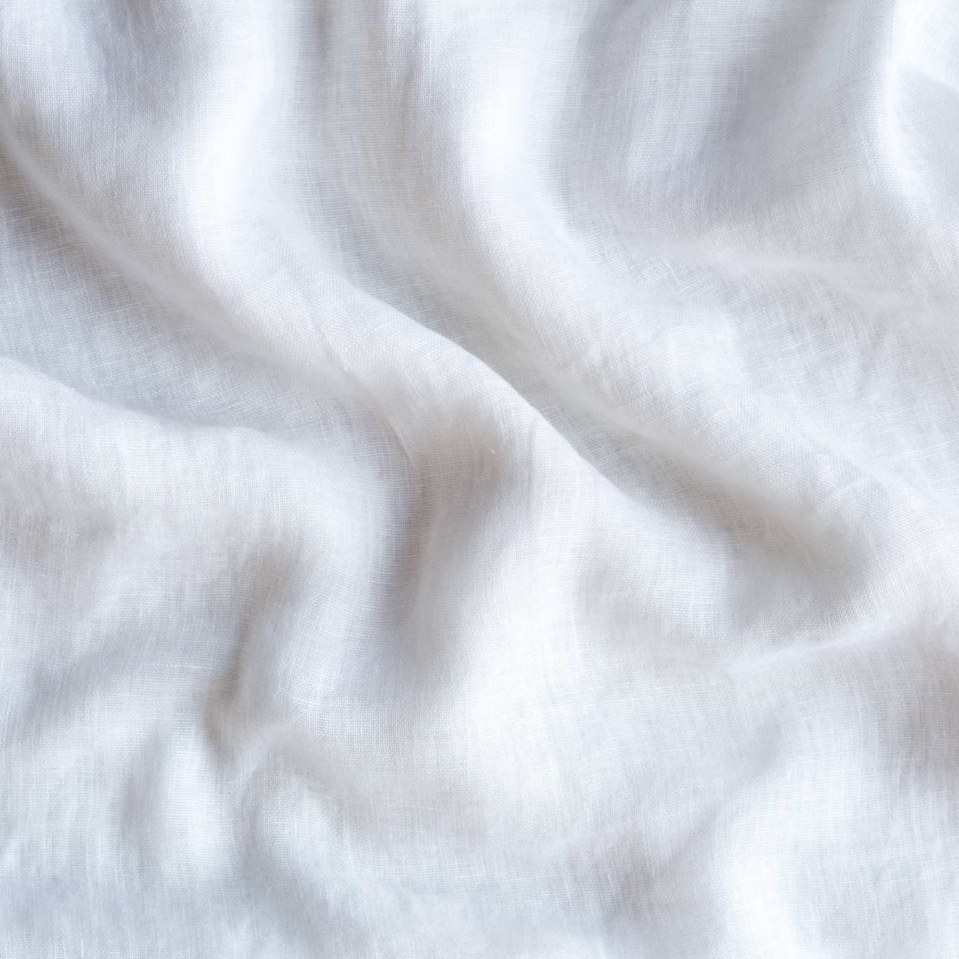 Close-up of White Bella Notte Linen Whisper fabric showing soft drape and relaxed linen weave texture.