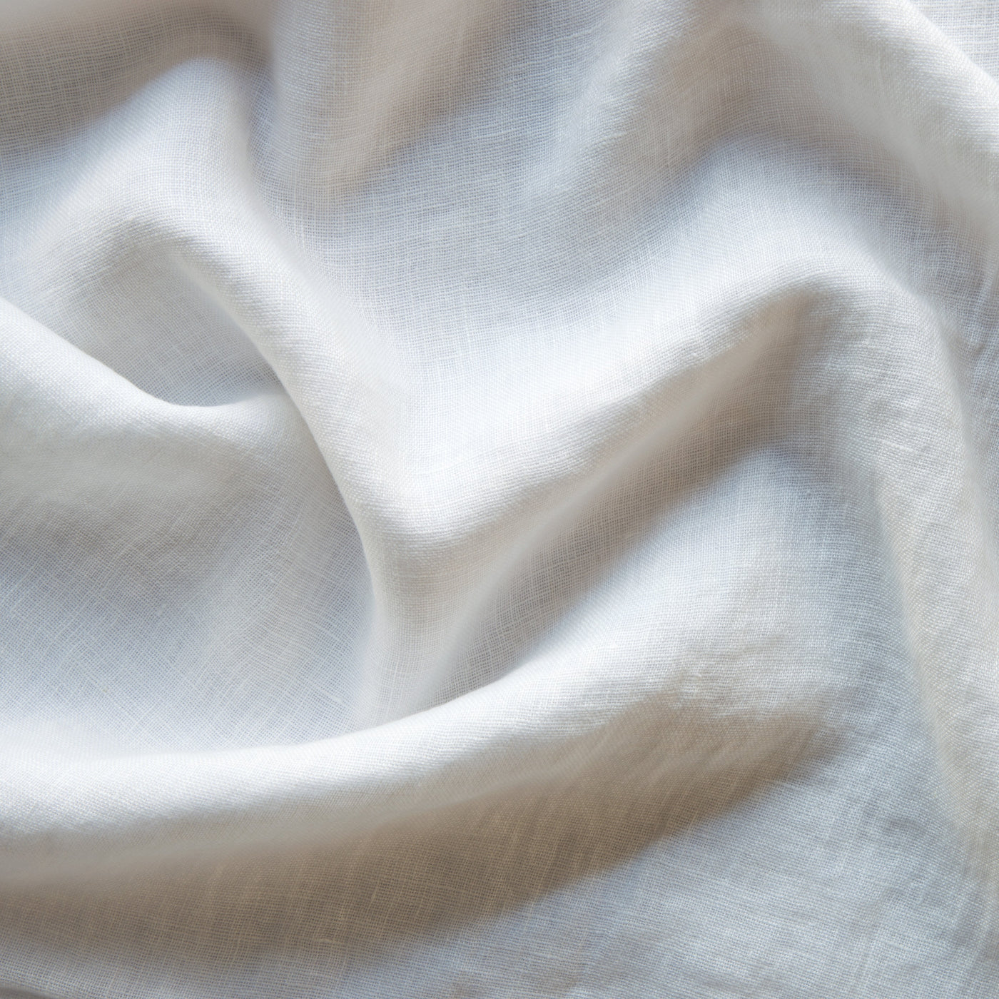 Close-up of Winter White linen fabric with soft draping and visible open weave texture.