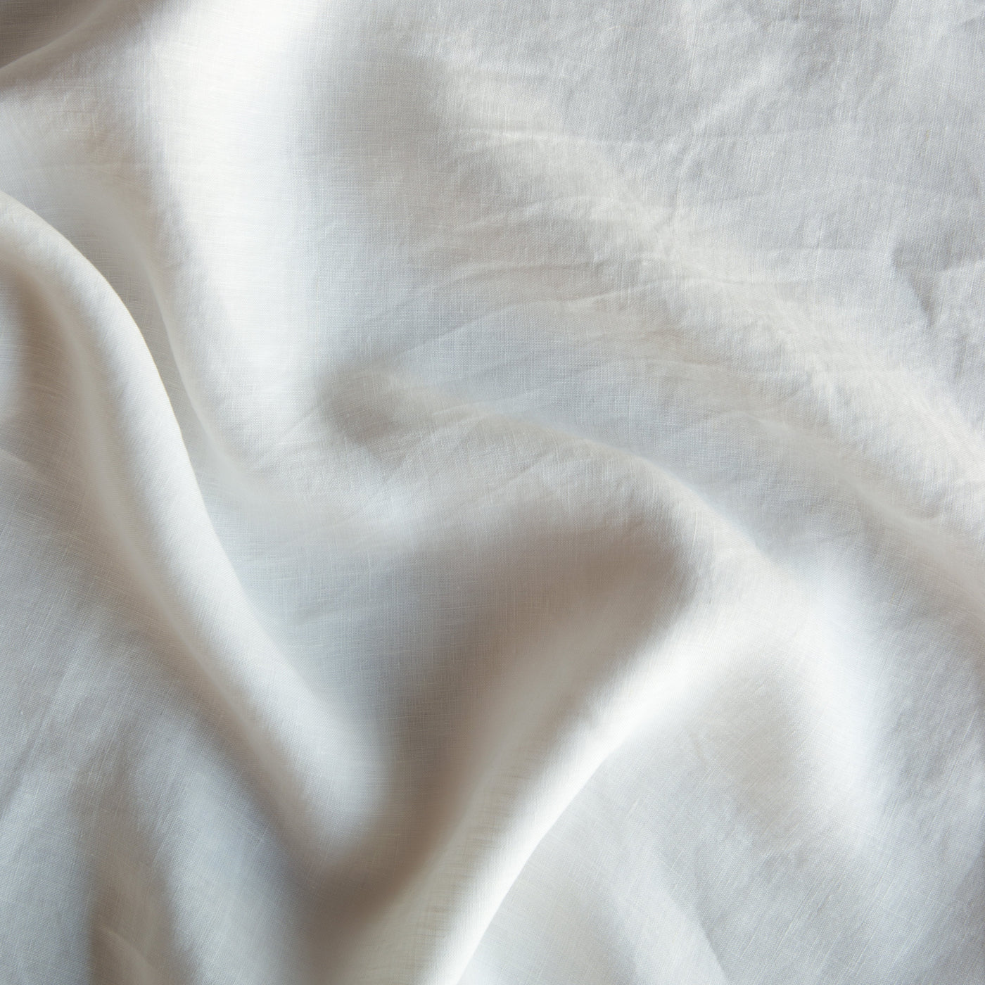Close-up of draped Winter White linen fabric with soft natural folds.
