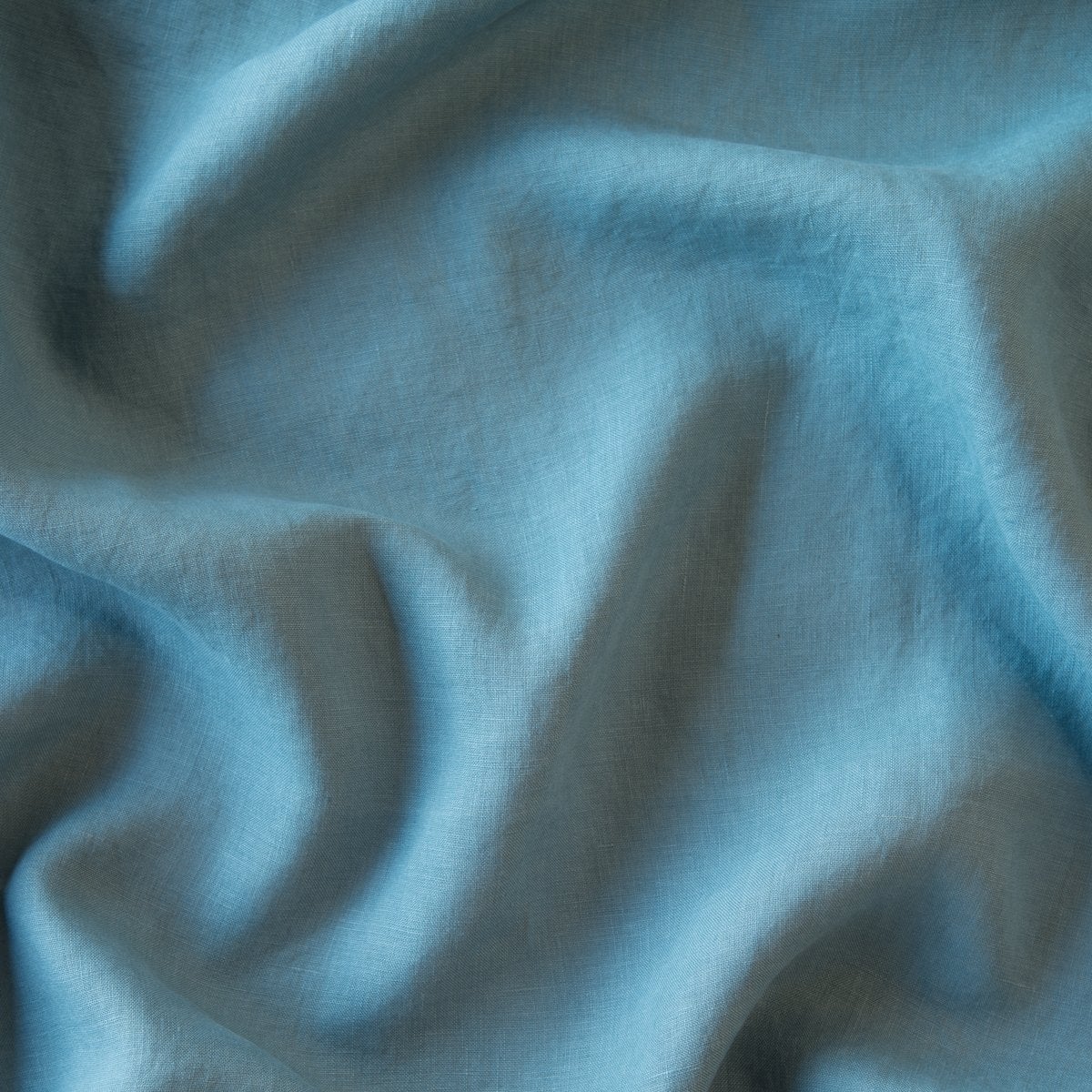 Close-up of Bella Notte Linen duvet cover in Cenote, showing soft drape and woven texture.
