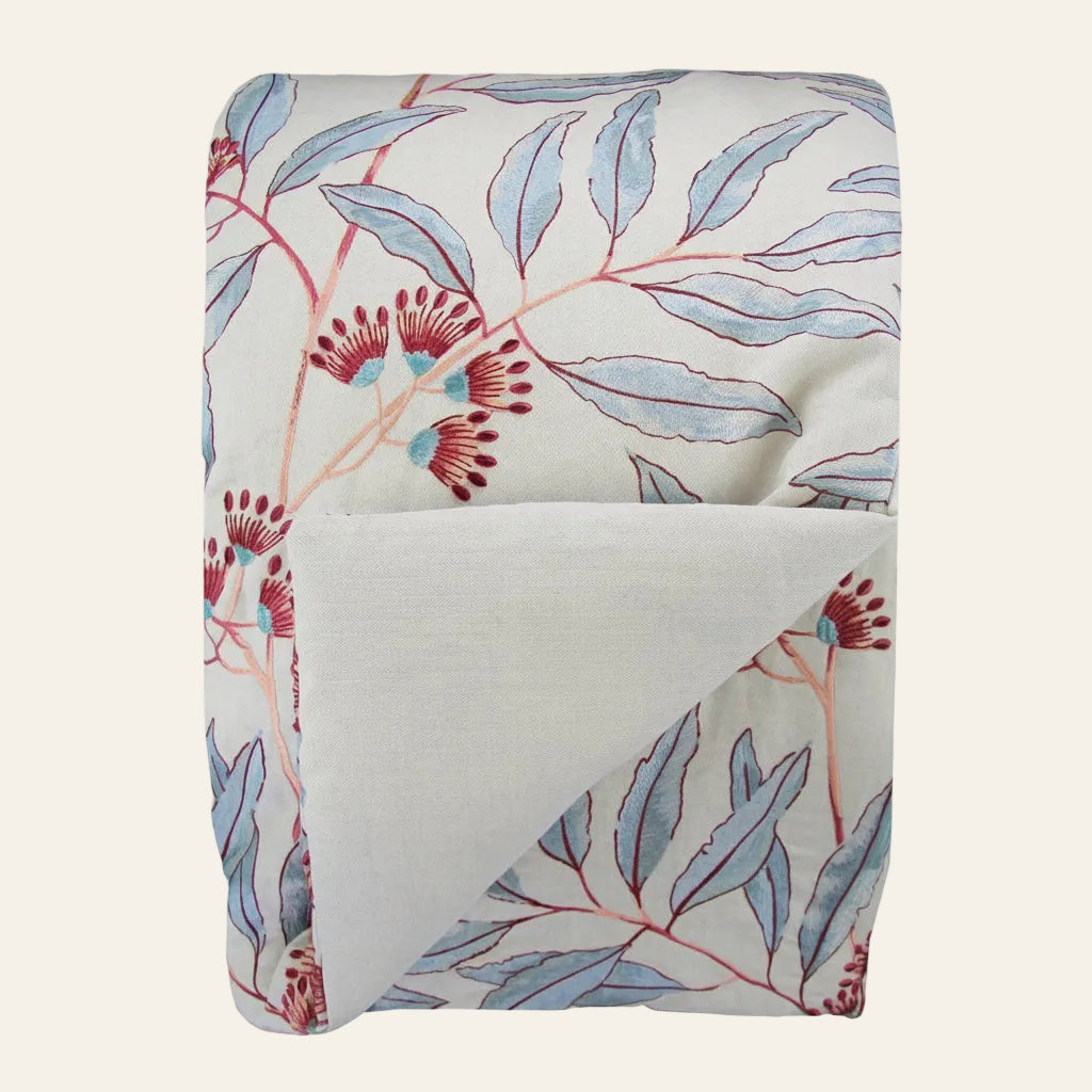Ann Gish Linenberry throw, ivory linen with blue botanical leaves and red berry print, folded.