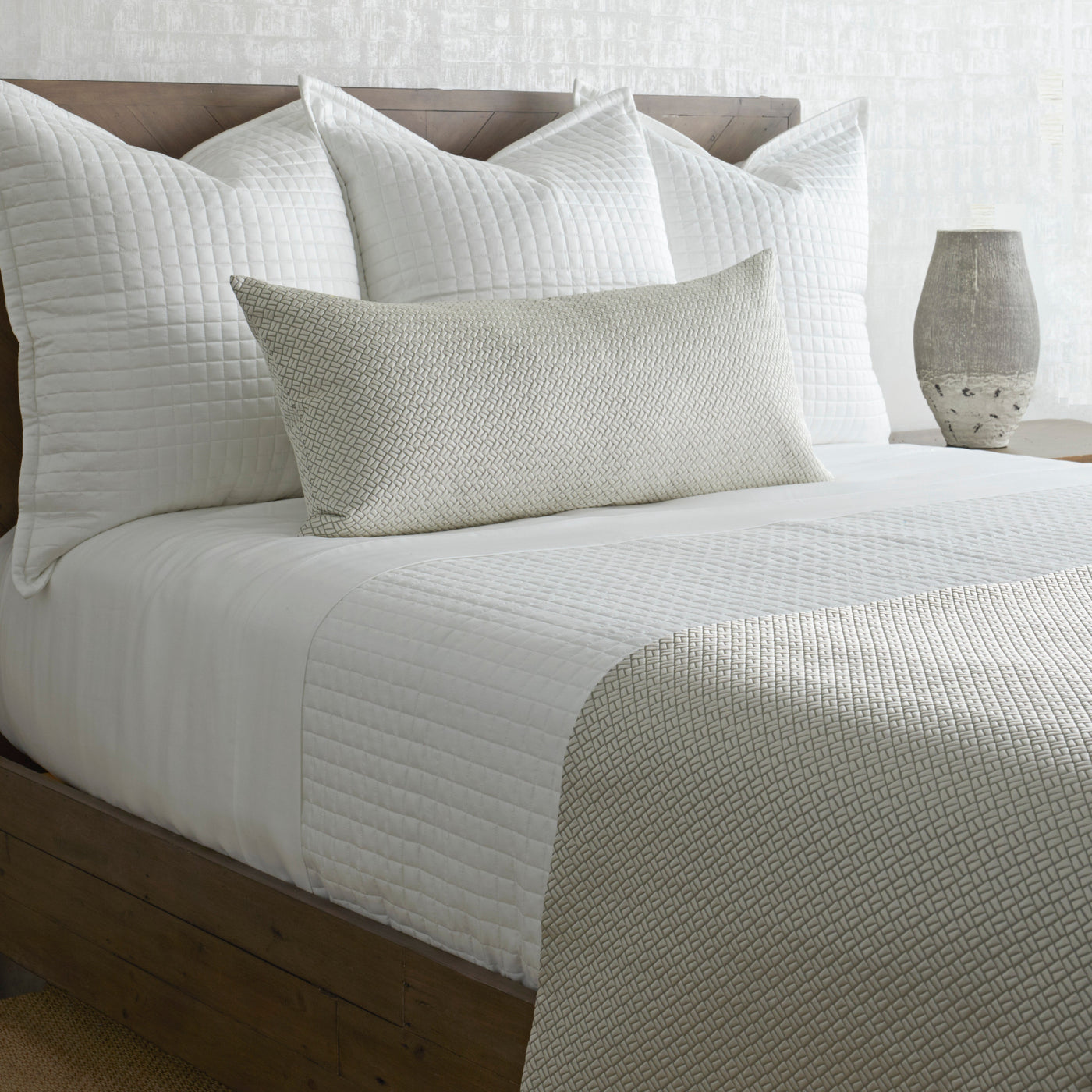 Ann Gish Link bed finisher in ivory and sage, styled on bed with quilted white shams.