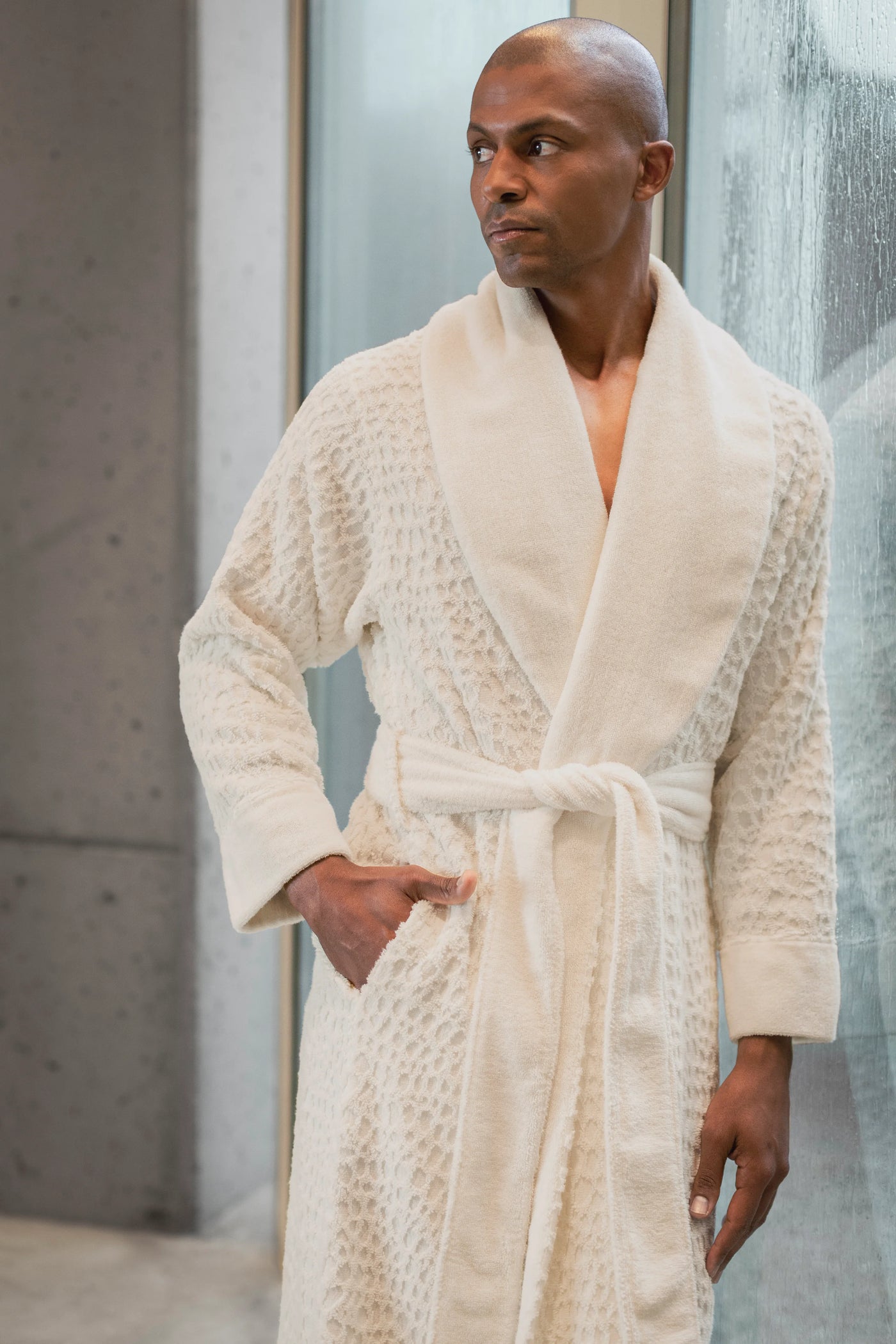 Close-up of ivory textured Lodge robe on male model, shawl collar and belted waist visible.