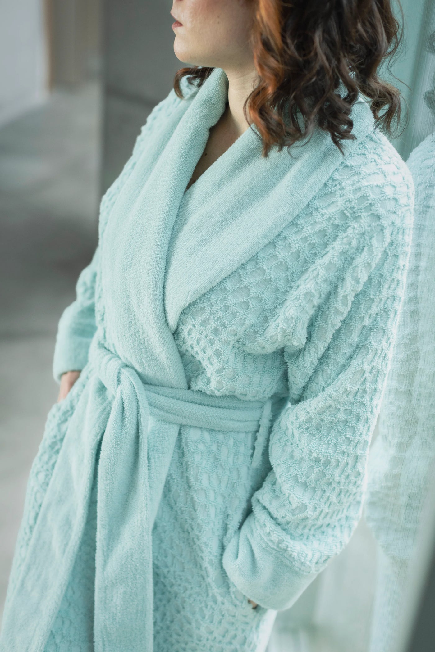 Close-up of aqua terry robe's textured waffle weave body and plush shawl collar.
