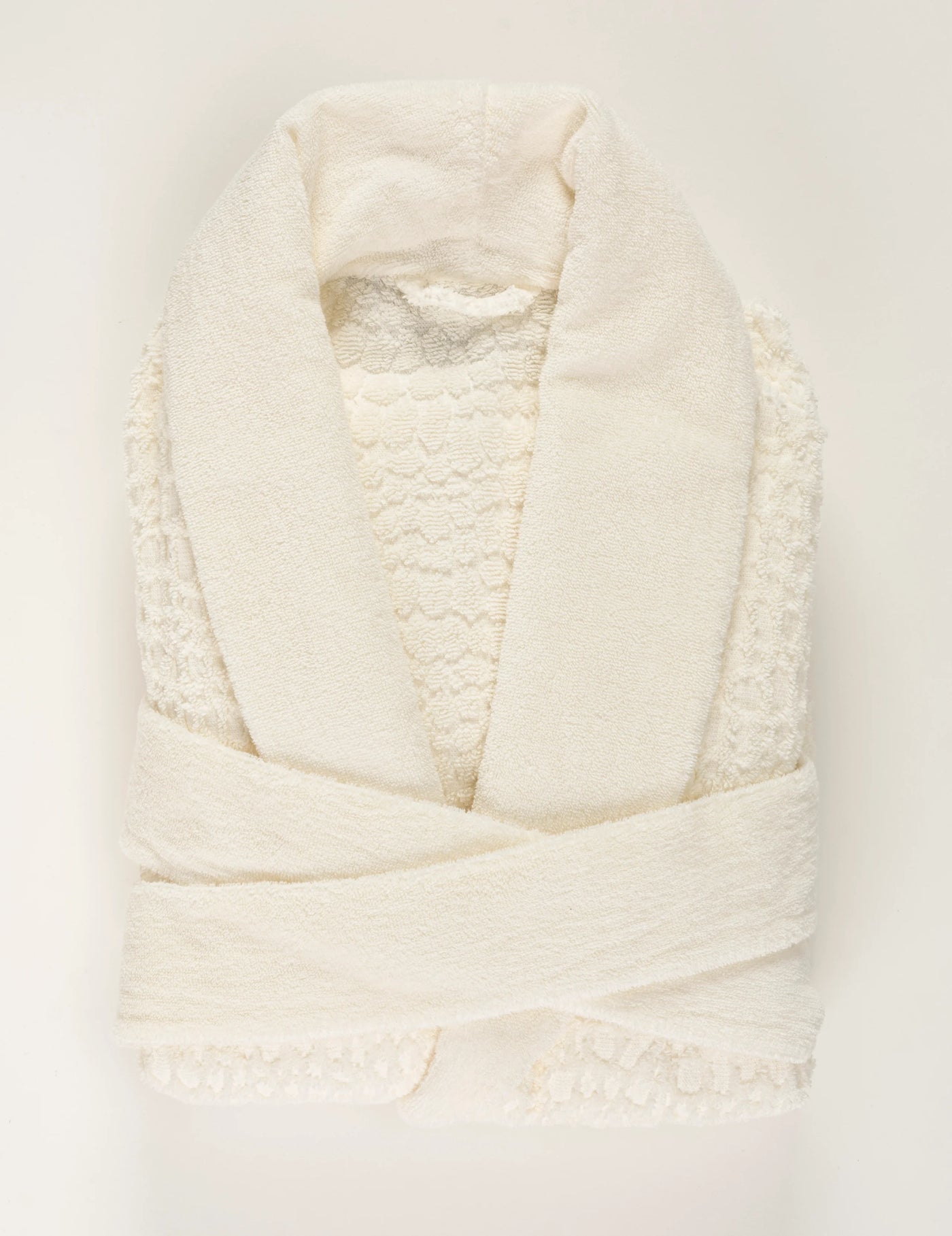Ivory terry robe folded flat, showing lace trim detail along front opening and hem.