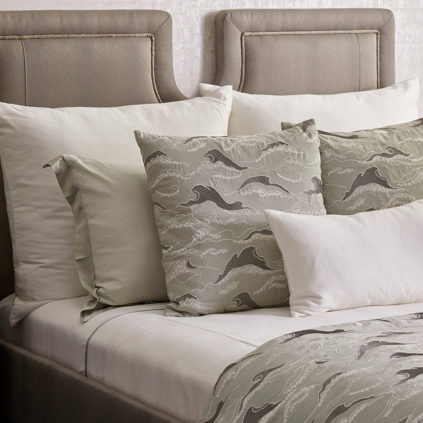 Sage and ivory wave-pattern kimono sham styled on a dressed bed with white euro shams.
