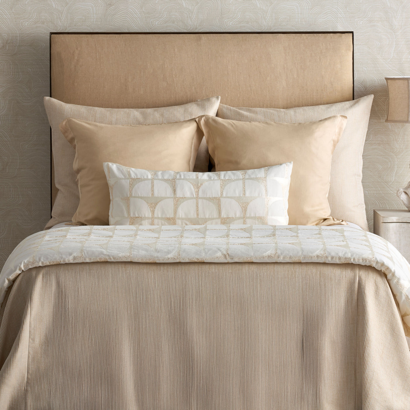 Close-up of Ann Gish Lover's Kimono sham styled on a champagne-toned bed with layered pillows.