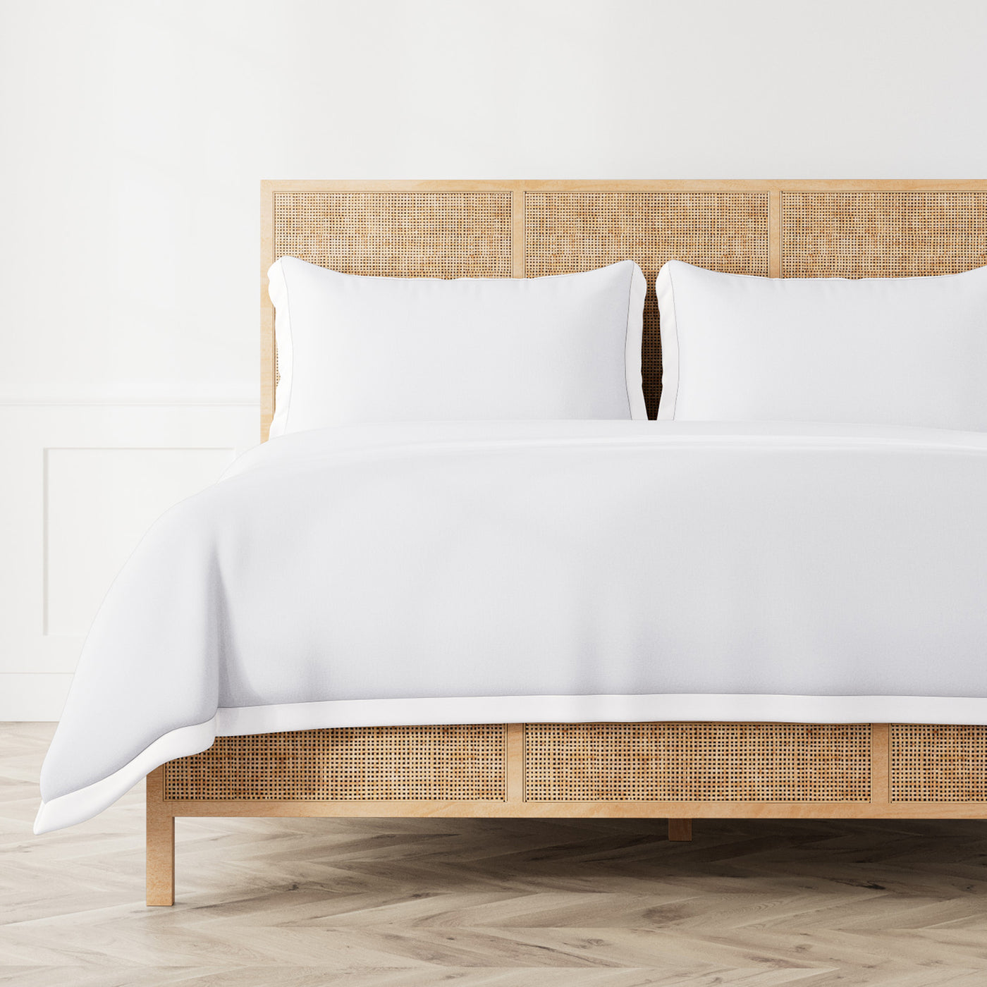 White Ann Gish Lover's Kimono duvet cover styled on rattan bed with matching shams.