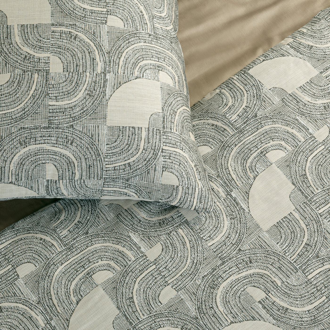 Close-up of Ann Gish Lugano comforter set showing geometric arc pattern in sage and ivory.