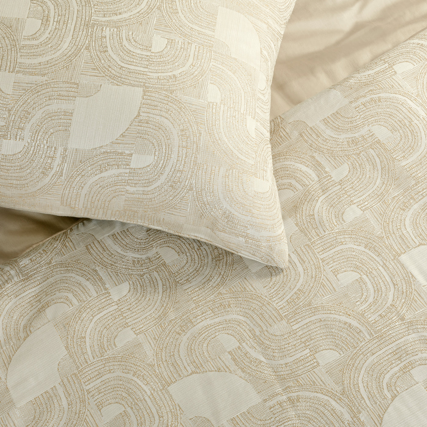 Close-up of Ann Gish Lugano comforter set in ivory, featuring a tonal arc and swirl jacquard pattern.