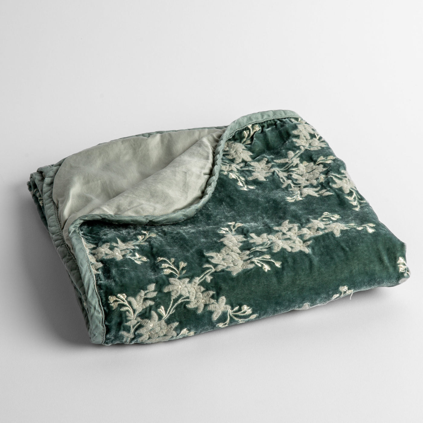 Bella Notte Lynette baby blanket in Eucalyptus, folded to show cream floral velvet and plain reverse.