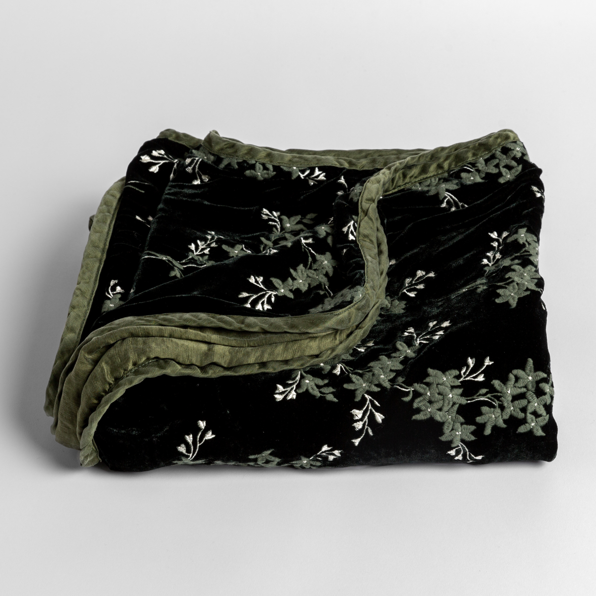 Bella Notte Lynette baby blanket in Juniper, folded to show floral embroidery on black velvet.