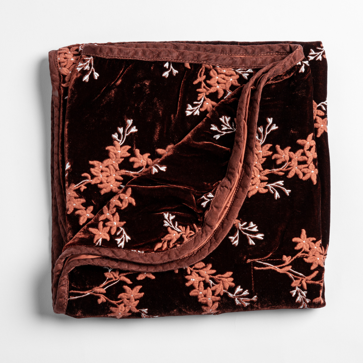 Bella Notte Lynette blanket in Autumn, folded to show floral branch embroidery on deep velvet.