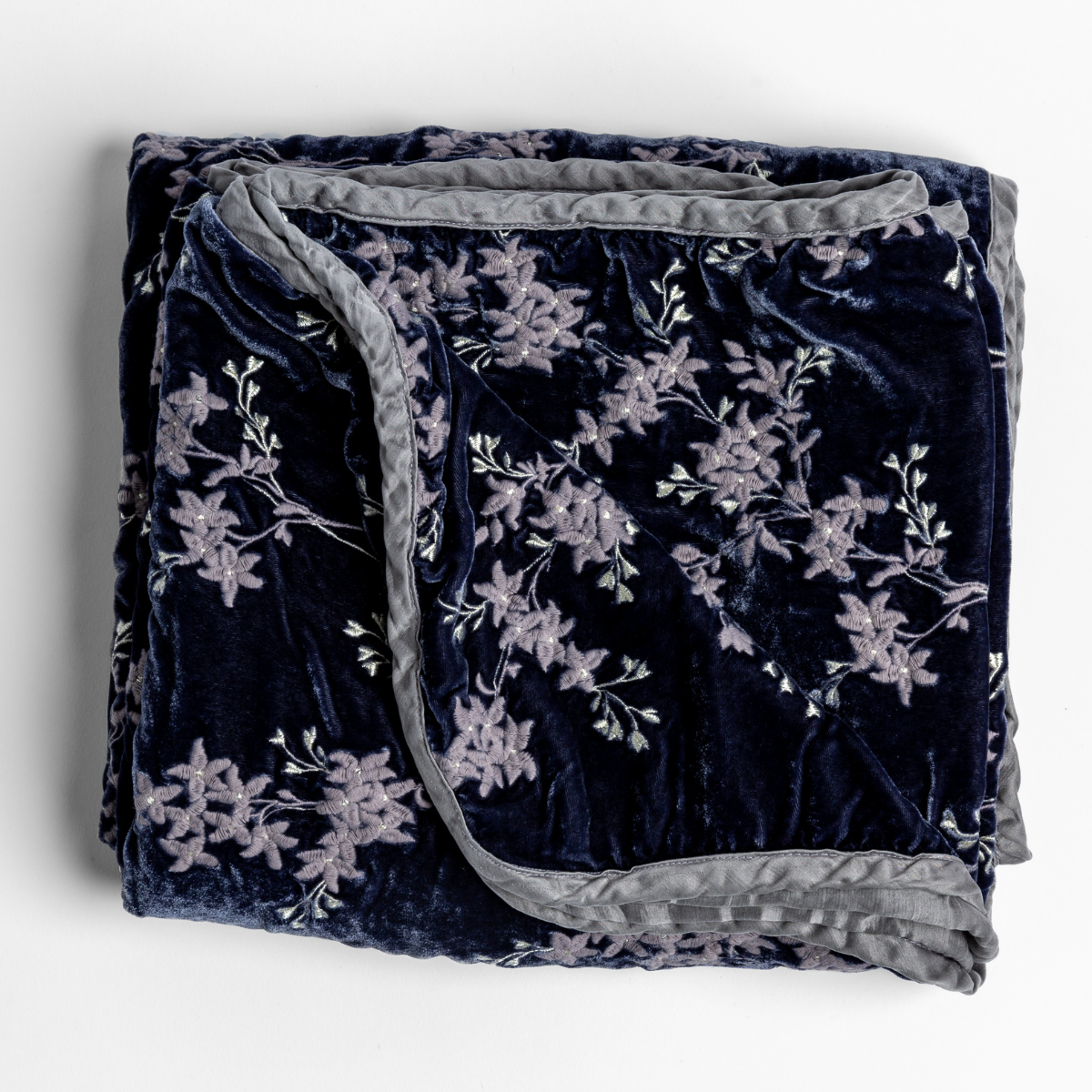 Bella Notte Lynette blanket in French Lavender, folded to show floral embroidery on navy velvet with grey trim.