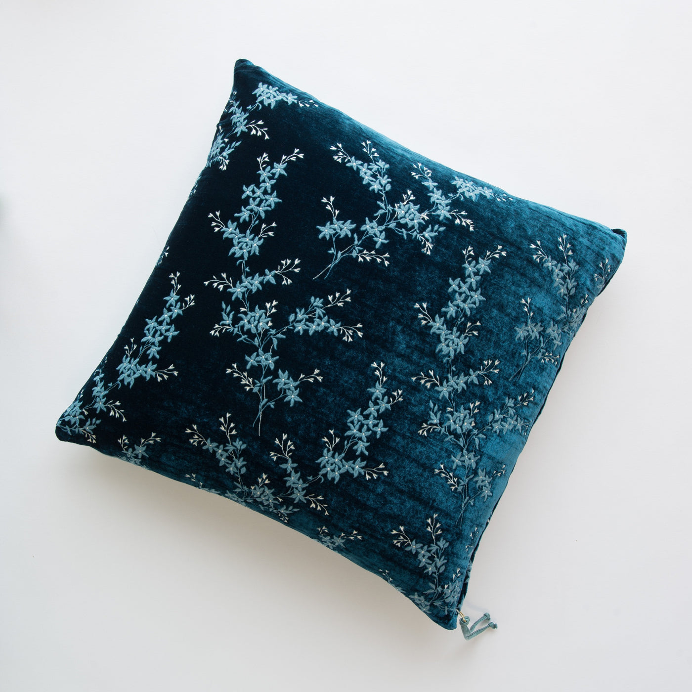 Lynette throw pillow in Cenote velvet, close-up overhead showing floral vine embroidery detail.