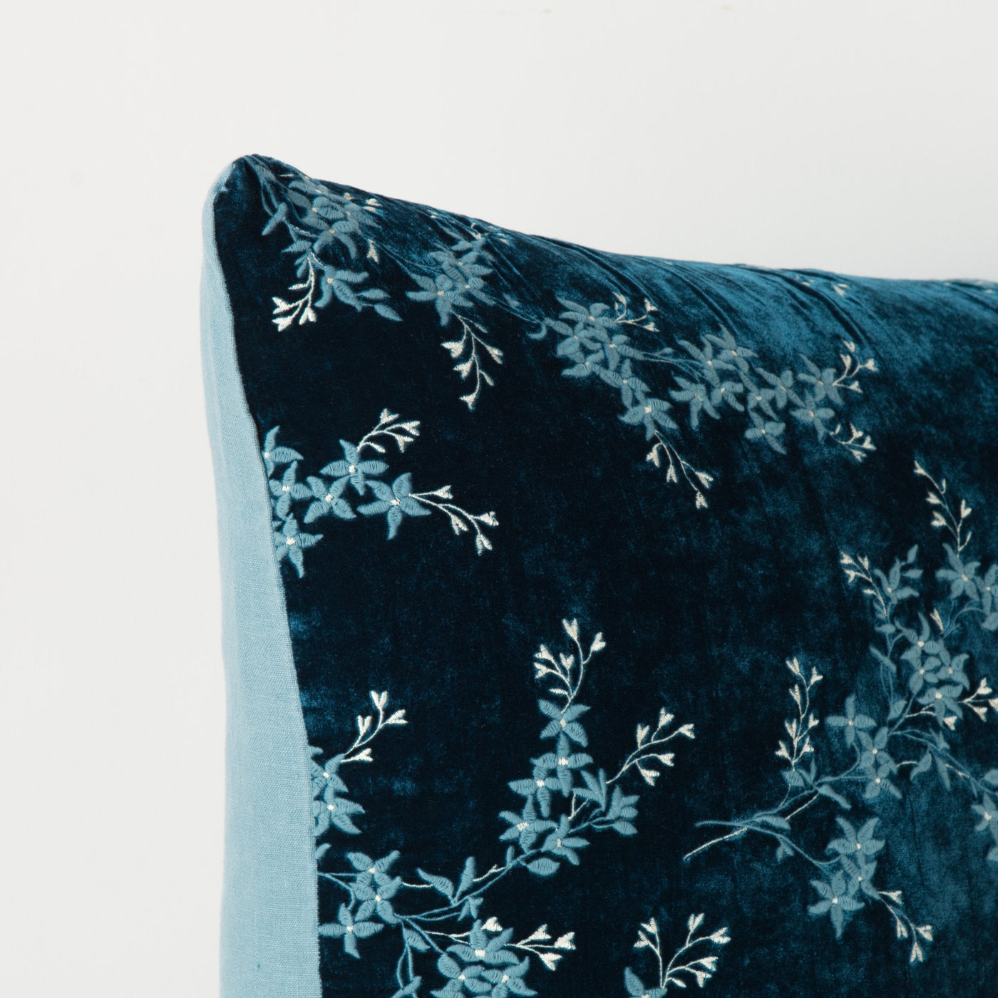 Close-up of Bella Notte Lynette sham corner in Cenote, showing floral embroidery on deep teal velvet.