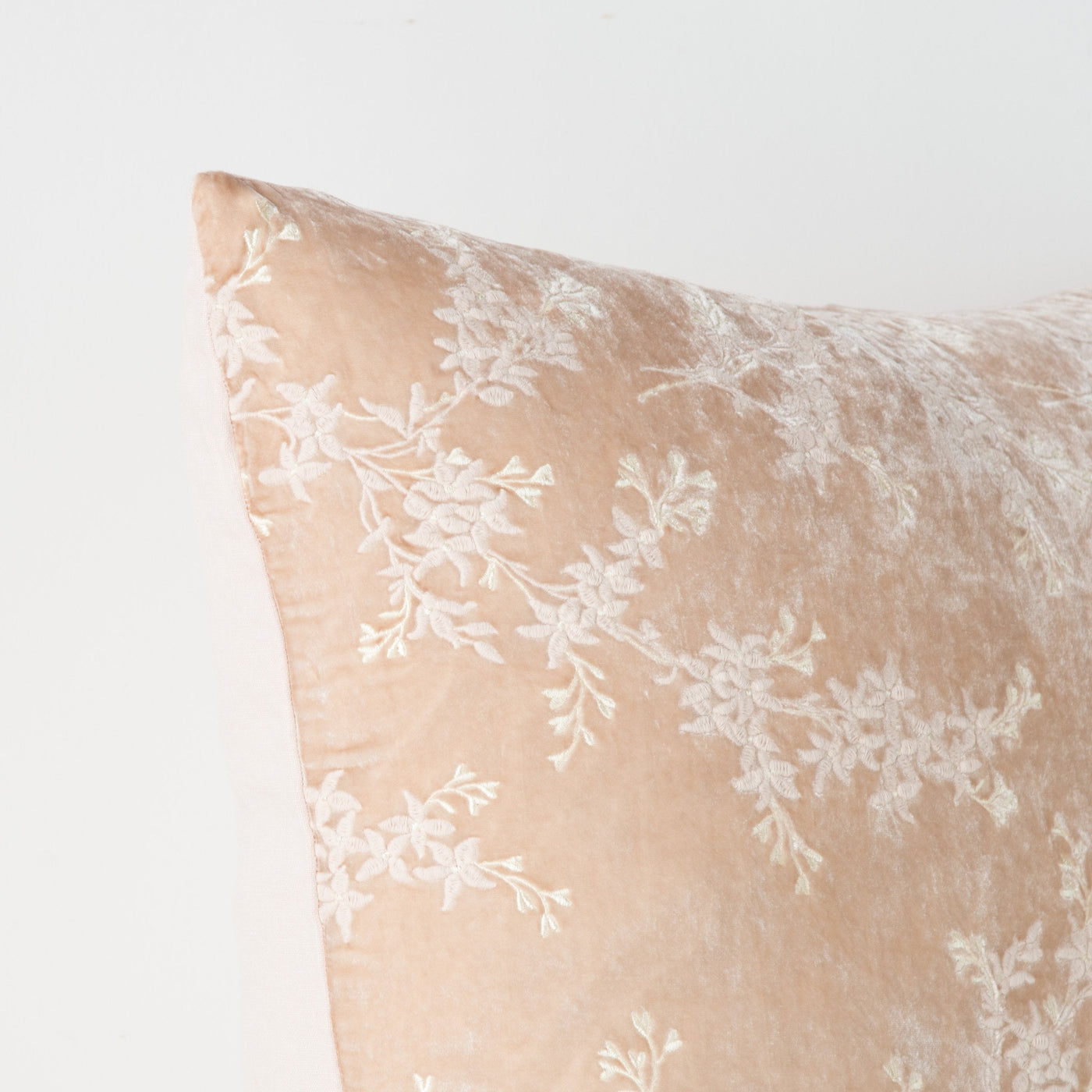 Corner detail of Pearl Bella Notte Lynette sham showing ivory floral embroidery on soft fabric.