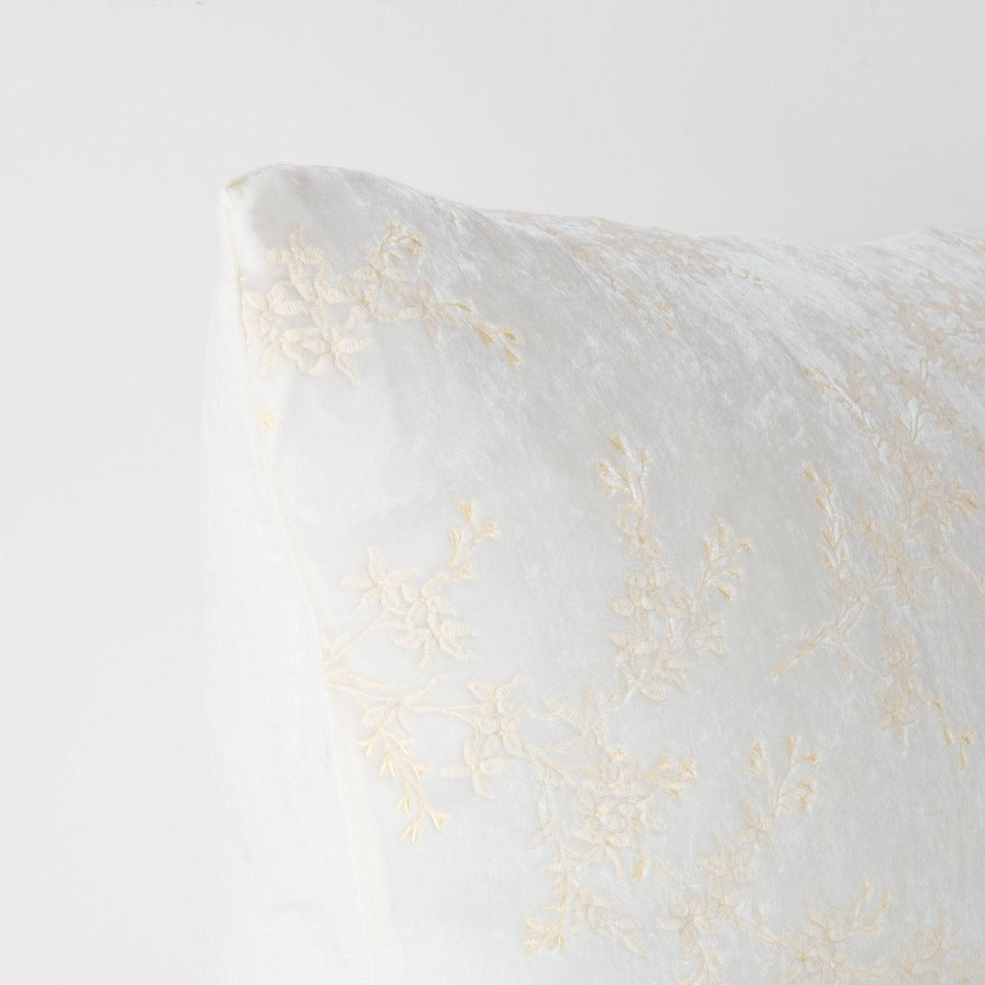 Close-up corner of Bella Notte Lynette sham in Winter White with delicate floral embroidery.