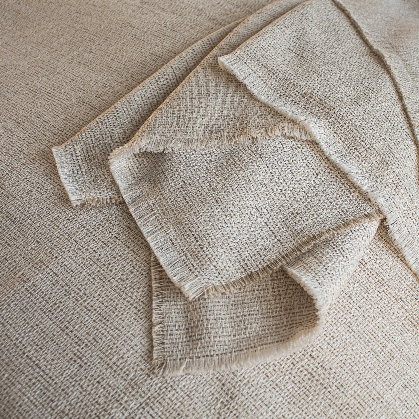 Ann Gish Macau raw-edge throw in natural, chunky woven texture with frayed hem detail.