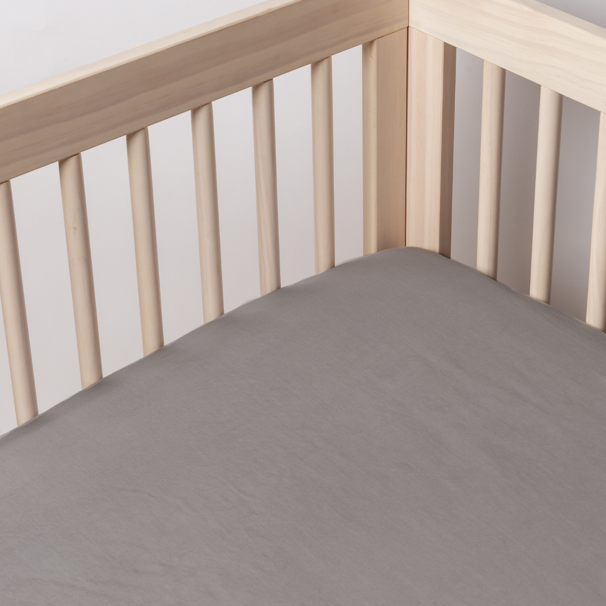 French Lavender crib sheet fitted smoothly in a natural wood crib, full mattress view.