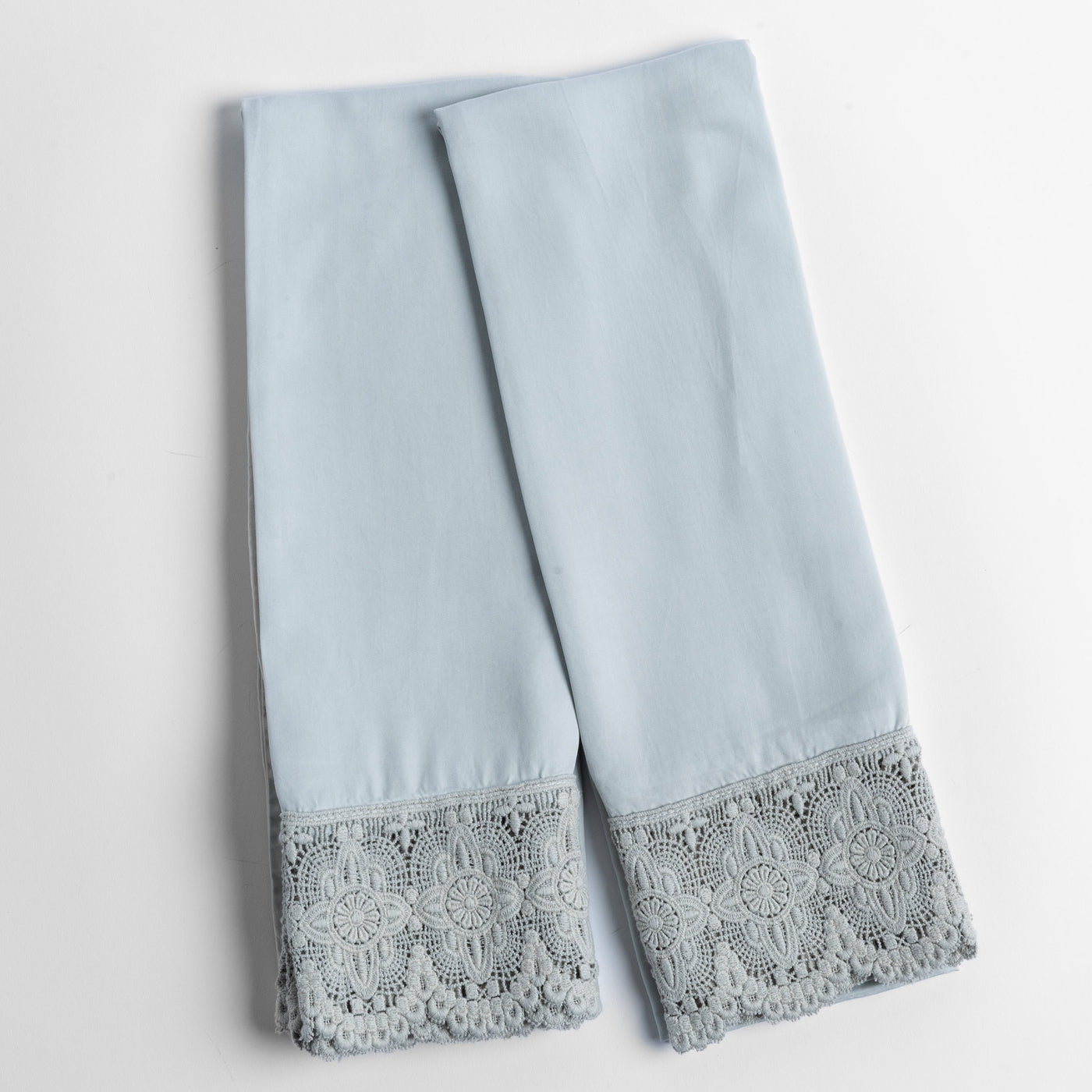 Folded Cloud Madera Luxe pillowcases showing intricate grey lace trim detail at hem.
