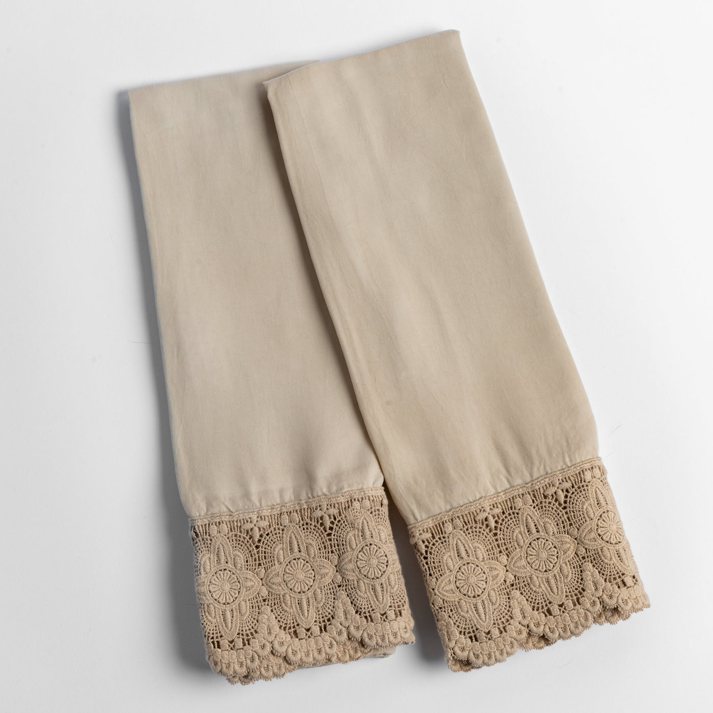 Close-up of Bella Notte Madera Luxe pillowcase pair in Honeycomb with floral crochet lace hem.