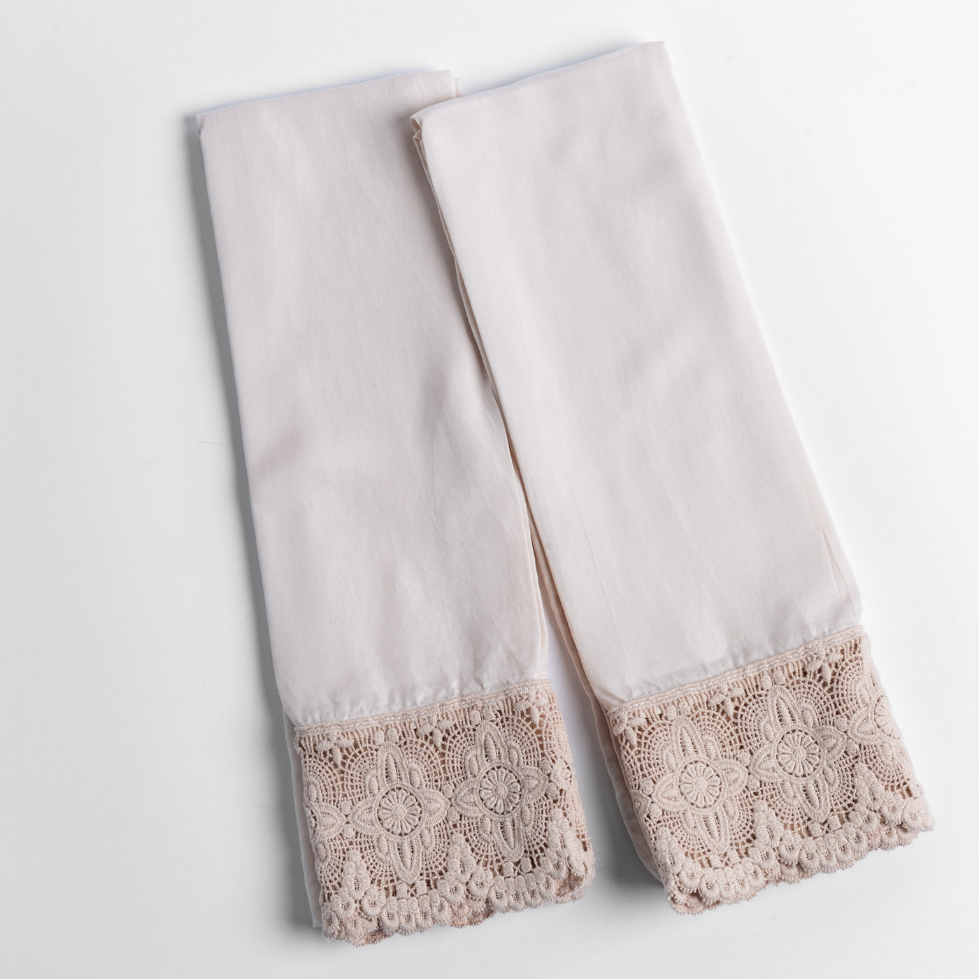 Pair of Pearl Madera Luxe pillowcases with floral crochet lace hem detail.