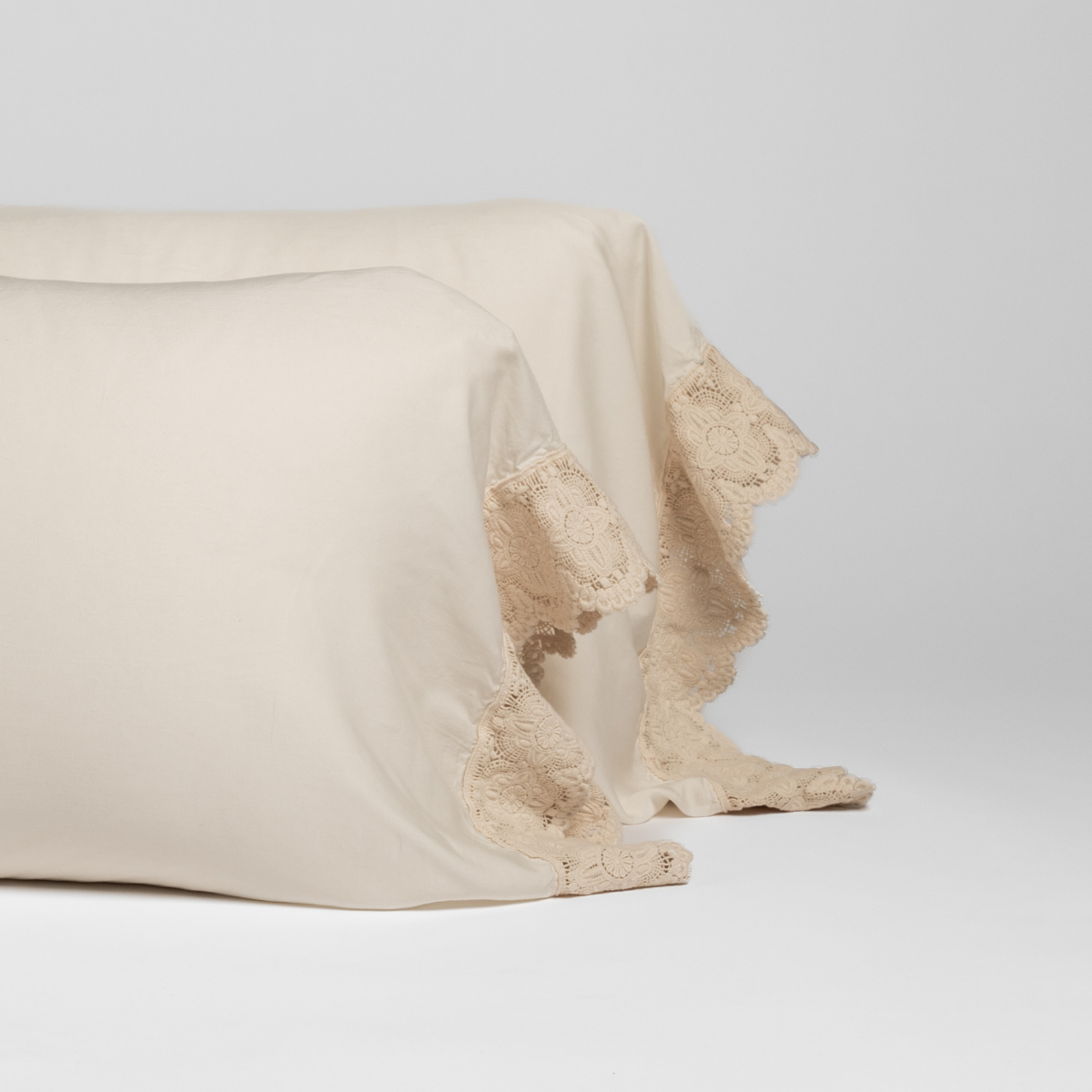 Close-up of Natural Madera Luxe pillowcase hem with delicate floral lace trim detail.