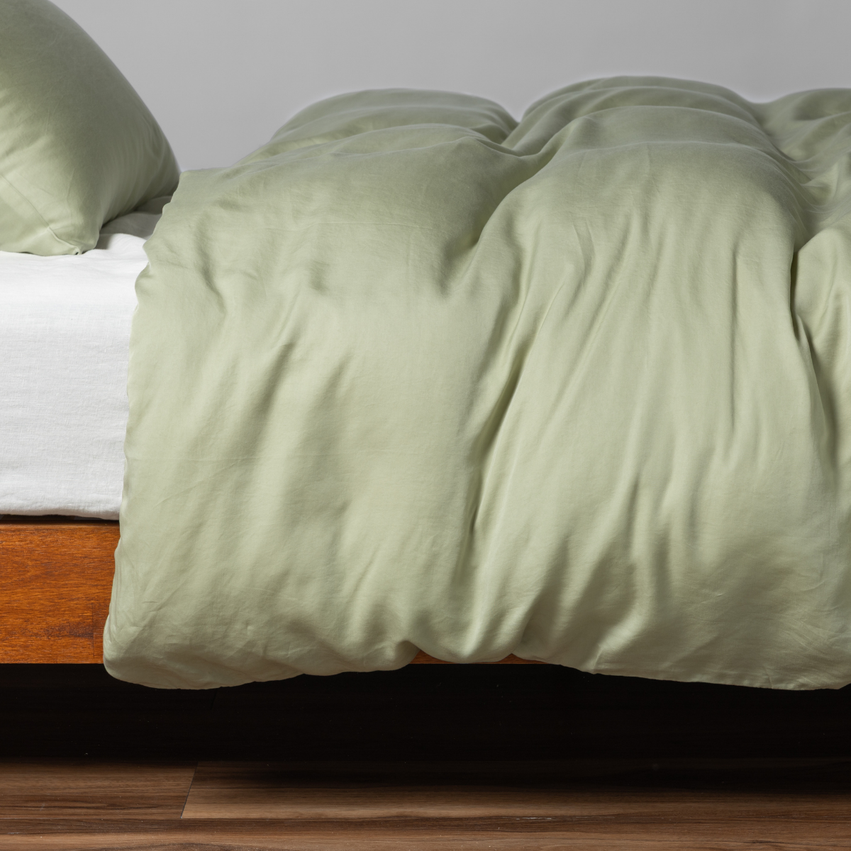 Relaxed Desert Sage duvet cover draped over bed, shot from foot-of-bed angle.