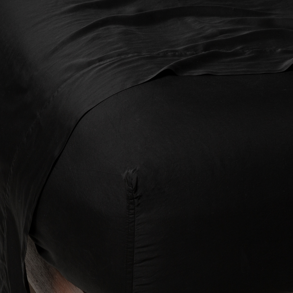 Close-up corner of Bella Notte Madera Luxe fitted sheet in Corvino with silky sheen.