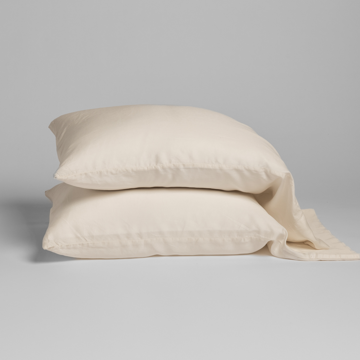 Bella Notte Madera Luxe pillowcases stacked in Natural, showing relaxed drape and fabric texture.