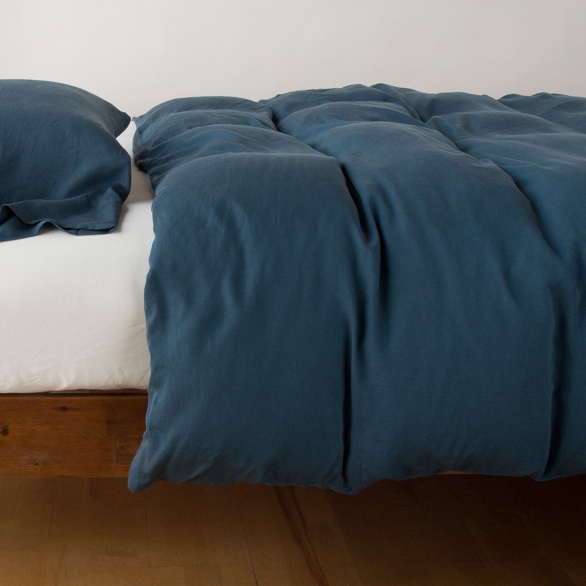 Madera Luxe duvet cover draped over bed, showing relaxed fabric texture and tufted surface detail.