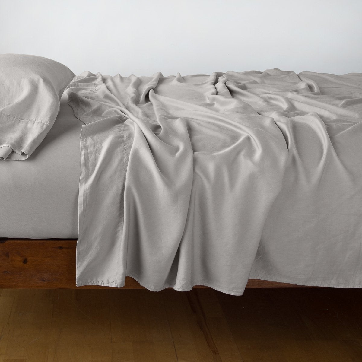 Fog Madera Luxe flat sheet draped loosely over a bed, showing fluid fabric drape.