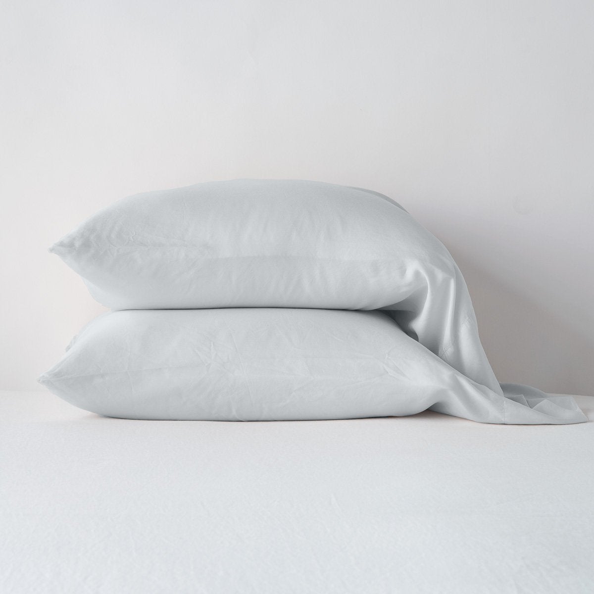 Two stacked Bella Notte Madera Luxe pillowcases in Cloud, draped softly against a white background.