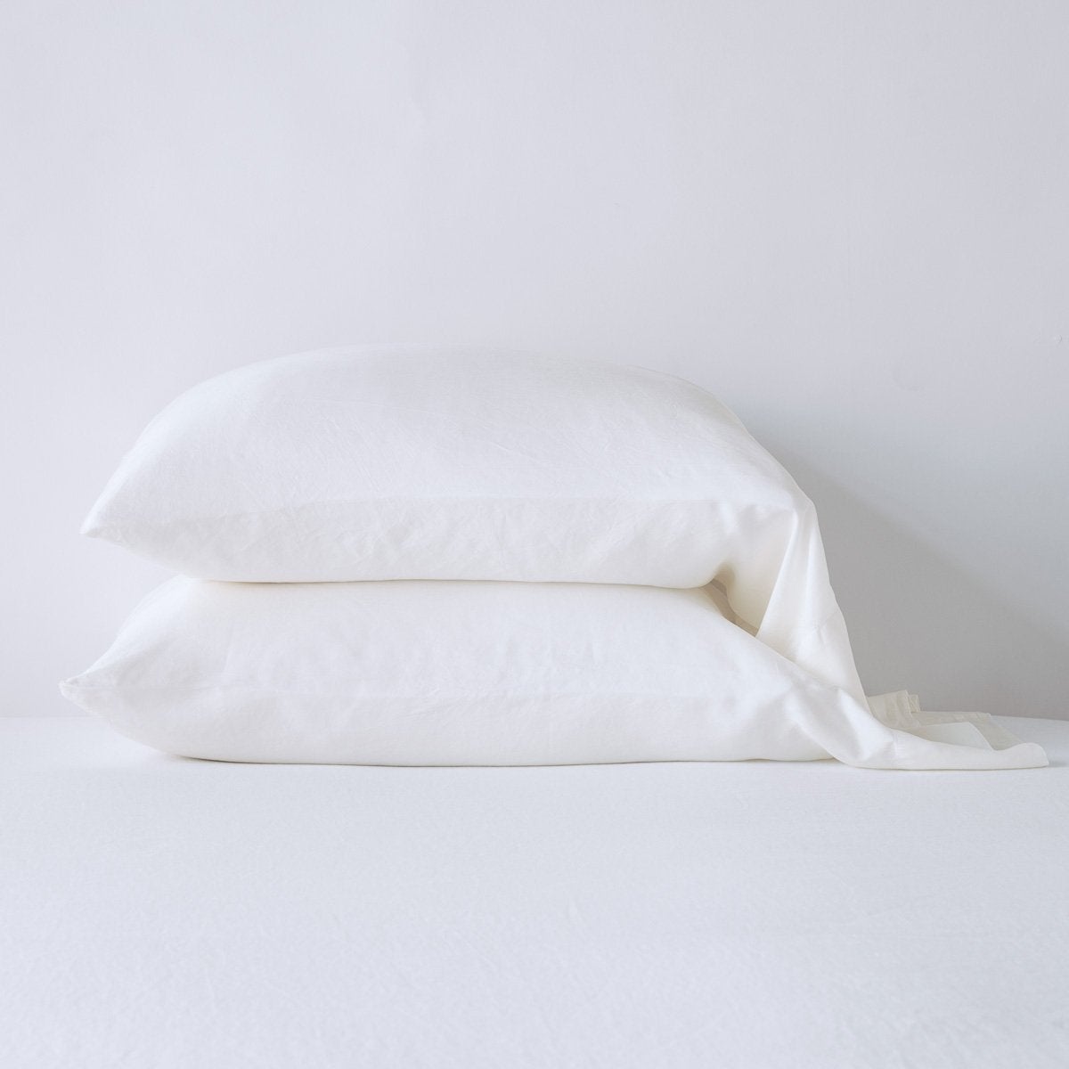 Two Winter White Bella Notte Madera Luxe pillowcases stacked, showing soft drape and relaxed texture.