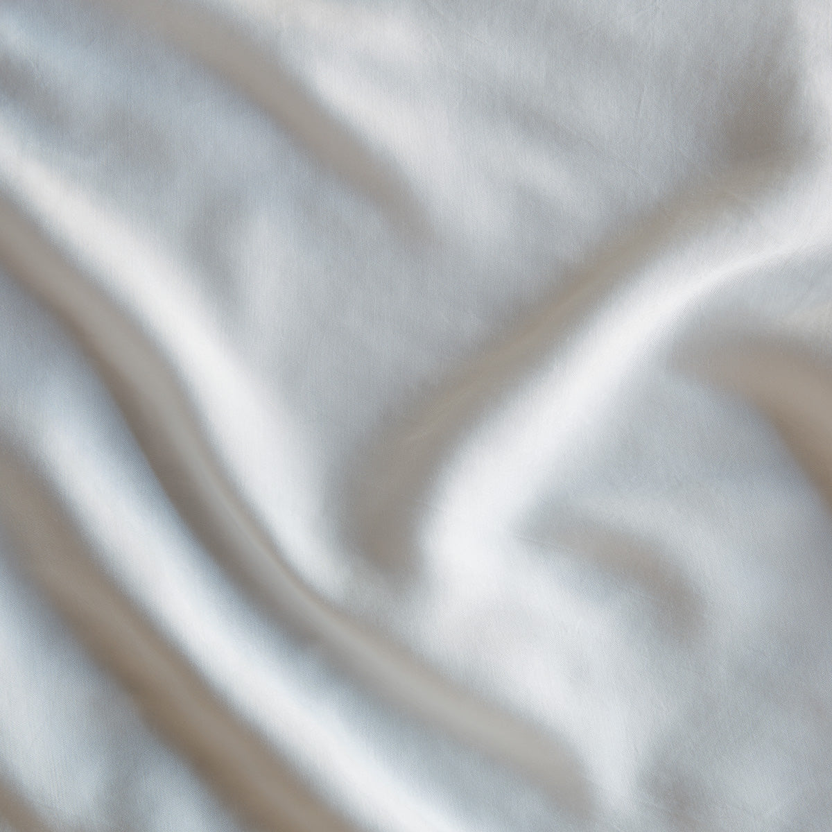 Close-up of Madera Luxe fitted sheet fabric showing silky drape and soft sheen.