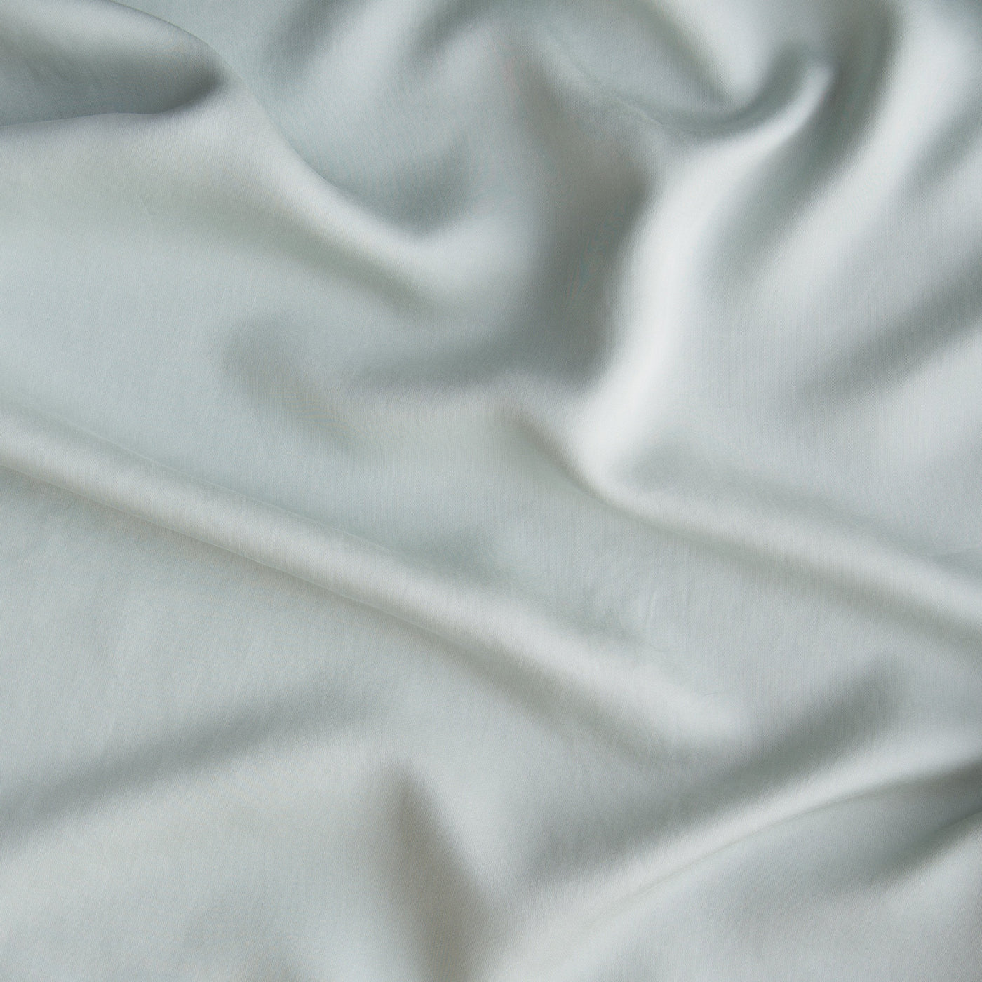 Close-up of Eucalyptus Madera Luxe fabric showing soft drape and smooth silky texture.