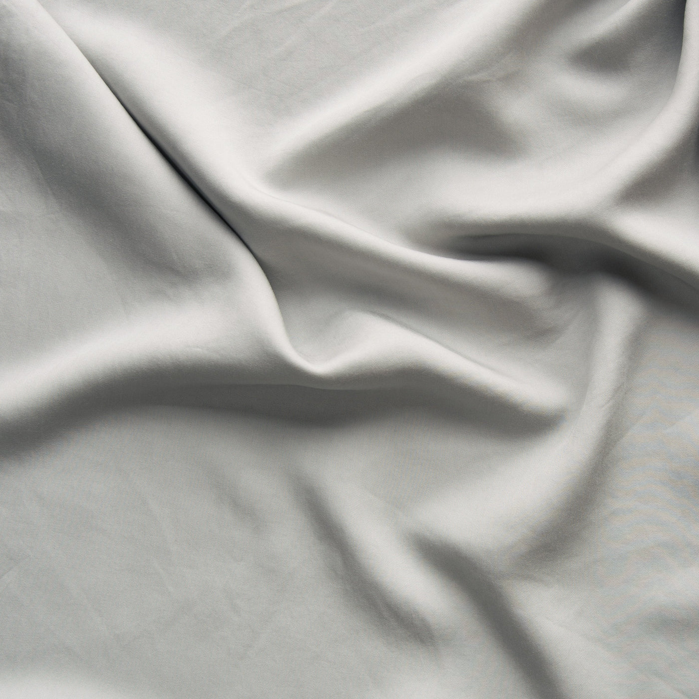 Softly draped Fog Madera Luxe fabric showing smooth, silky texture and gentle folds.