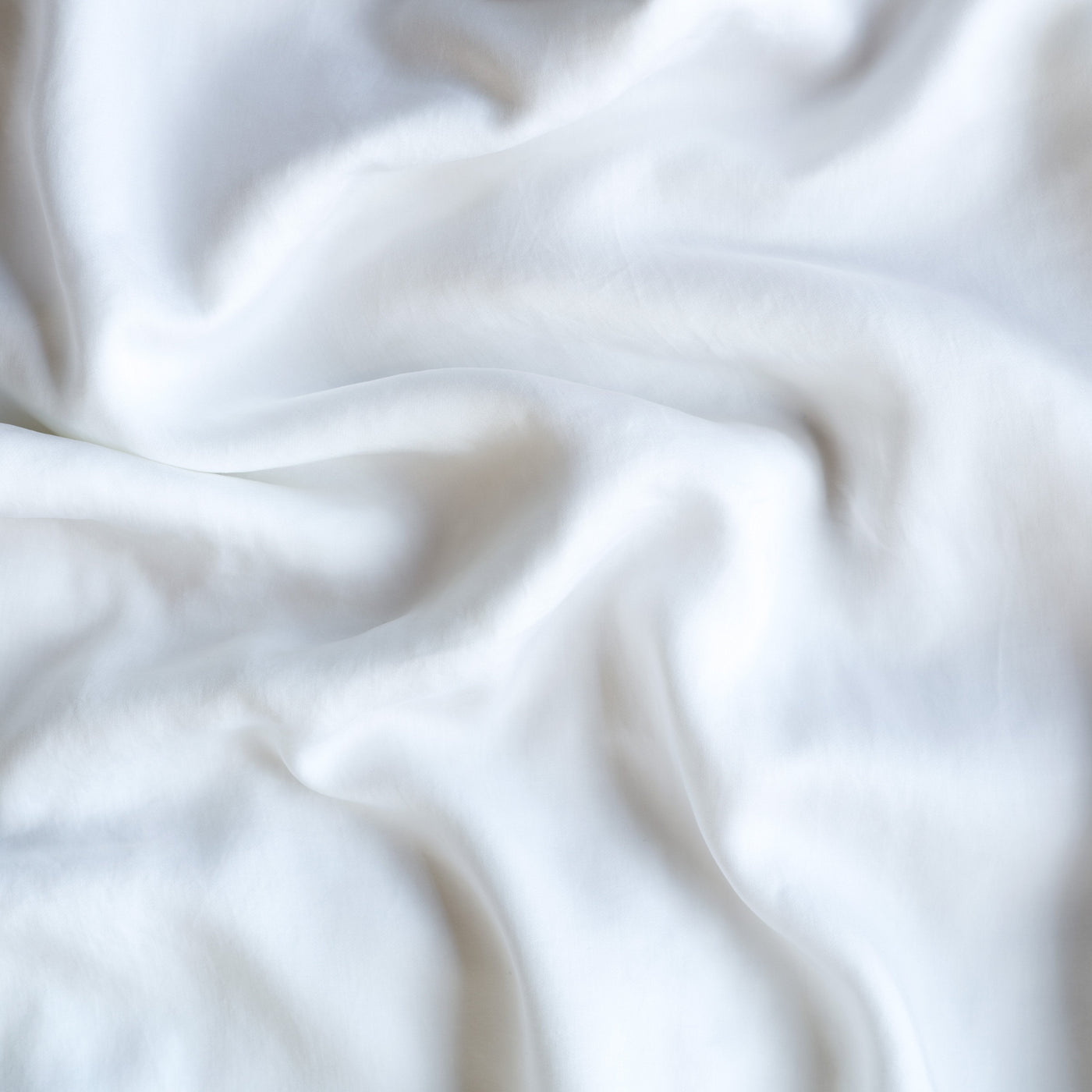 Close-up of White Bella Notte Madera Luxe fitted sheet showing soft draped folds.