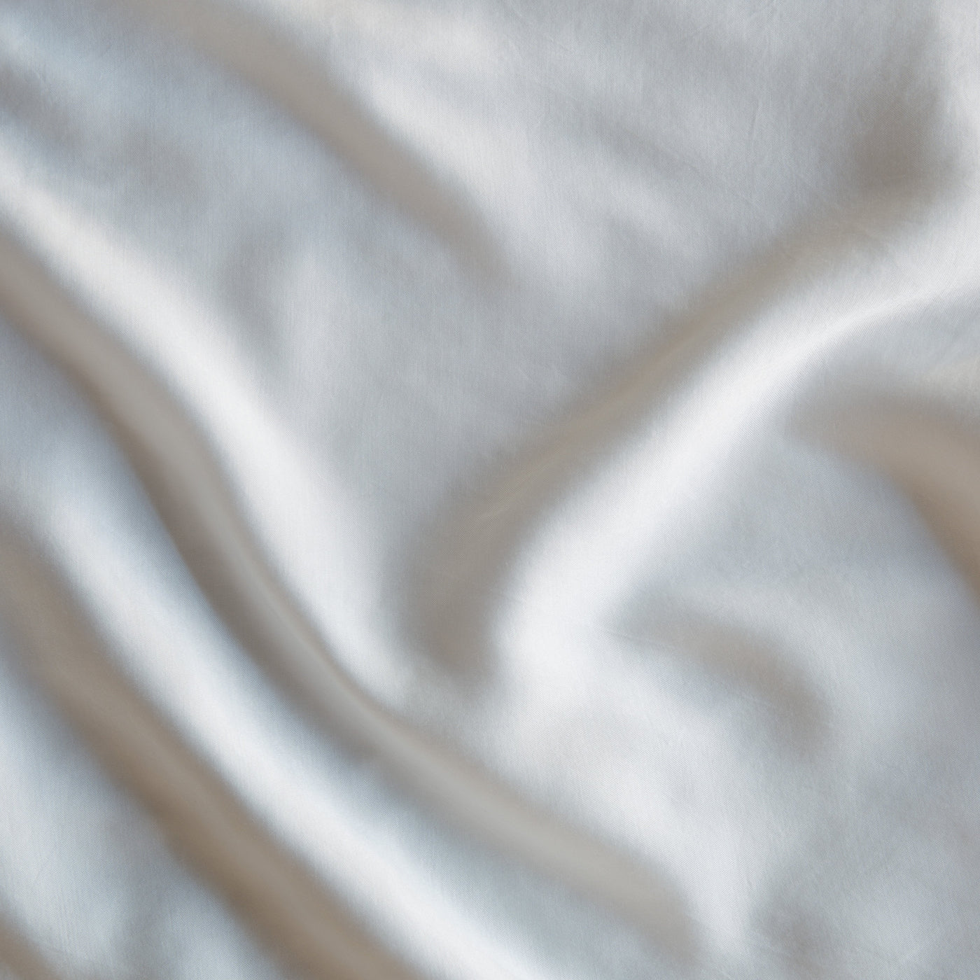 Close-up of Winter White Madera Luxe fabric showing soft sheen and gentle draping folds.