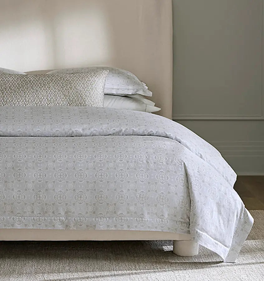 Low-angle view of Sferra Maiolica duvet cover's silver medallion jacquard pattern.