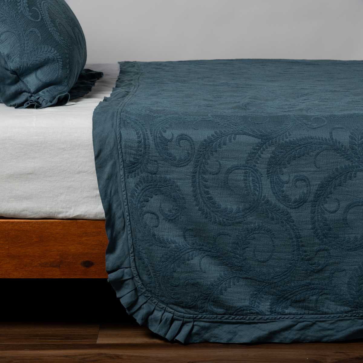 Bella Notte Marisette bedspread in Midnight, showing ruffle trim detail at bed corner.