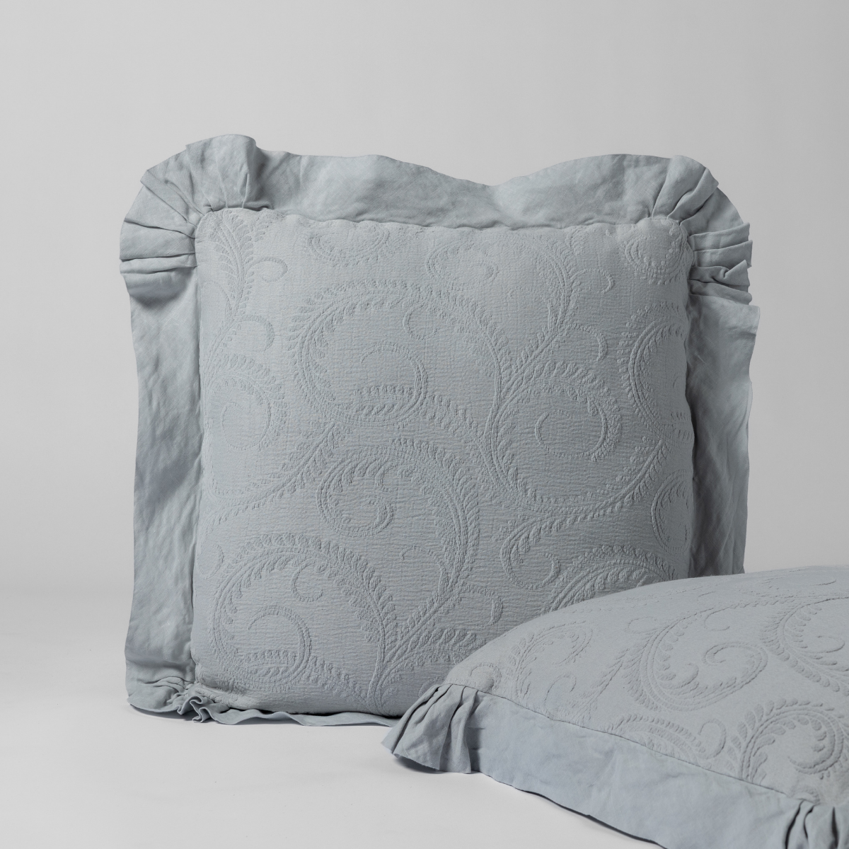Bella Notte Marisette sham in Cloud, showing ruffled flange edge and scrollwork quilting detail.