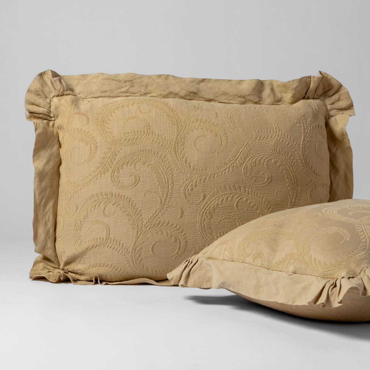 Honeycomb Marisette sham close-up showing quilted scroll pattern and ruffled flange edge.