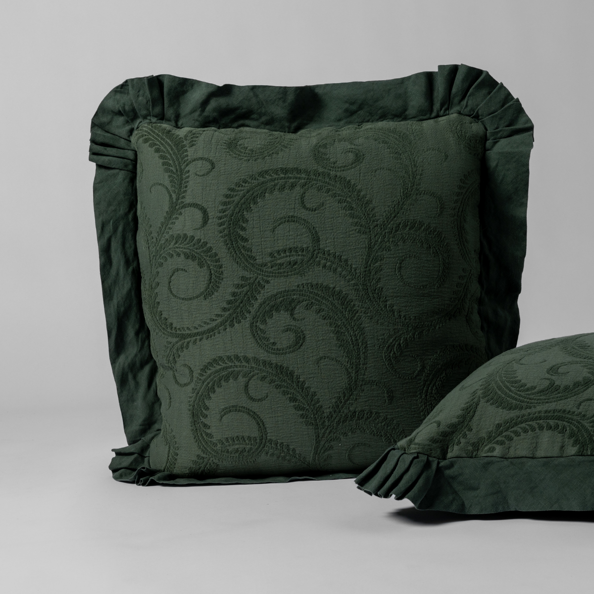 Bella Notte Marisette sham in Juniper, showing ruffled border and scrolling embroidery detail.